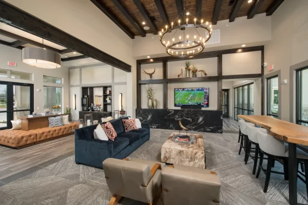 Clubhouse interior with ample lounging, a large television, and a coffee station