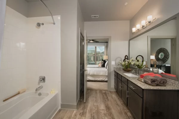 Bathroom with large, granite top vanity, shower bath, ample storage, and connected to the bedroom