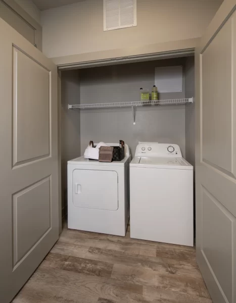 In-unit, full size washer and dryer in a closet with shelving space