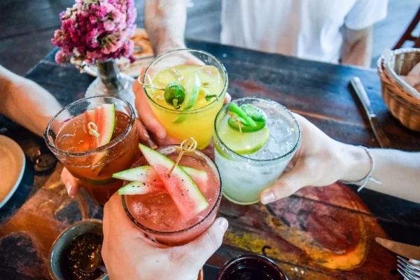 Overhead shot of four cocktails being clinked together